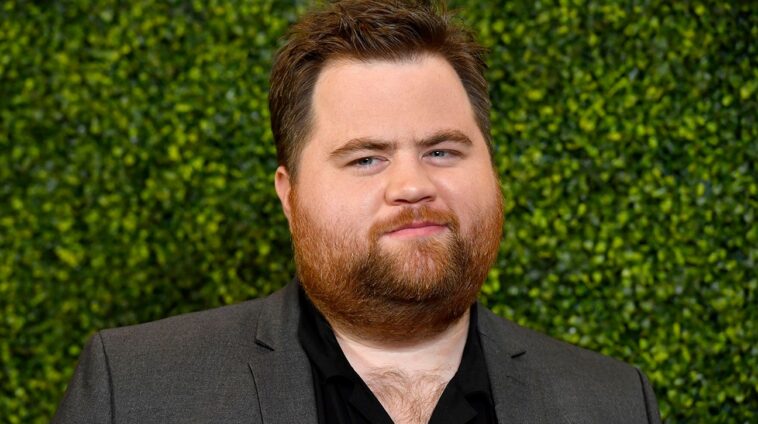 découvrez la passion de paul walter hauser pour les bandes dessinées et la pression de jouer chris farley dans ses rôles au cinéma.